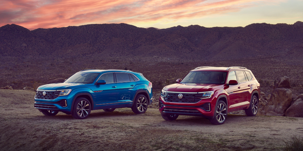 2026 Volkswagen Atlas and Tiguan parked next to each other with a mountain range in the background