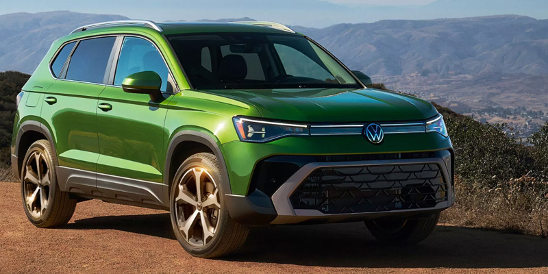 Green Volkswagen SUV on a mountain road.
