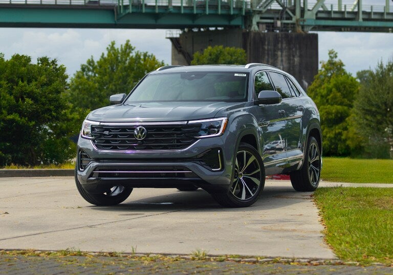 A blue SUV Cross Sport parked in front of bridge.